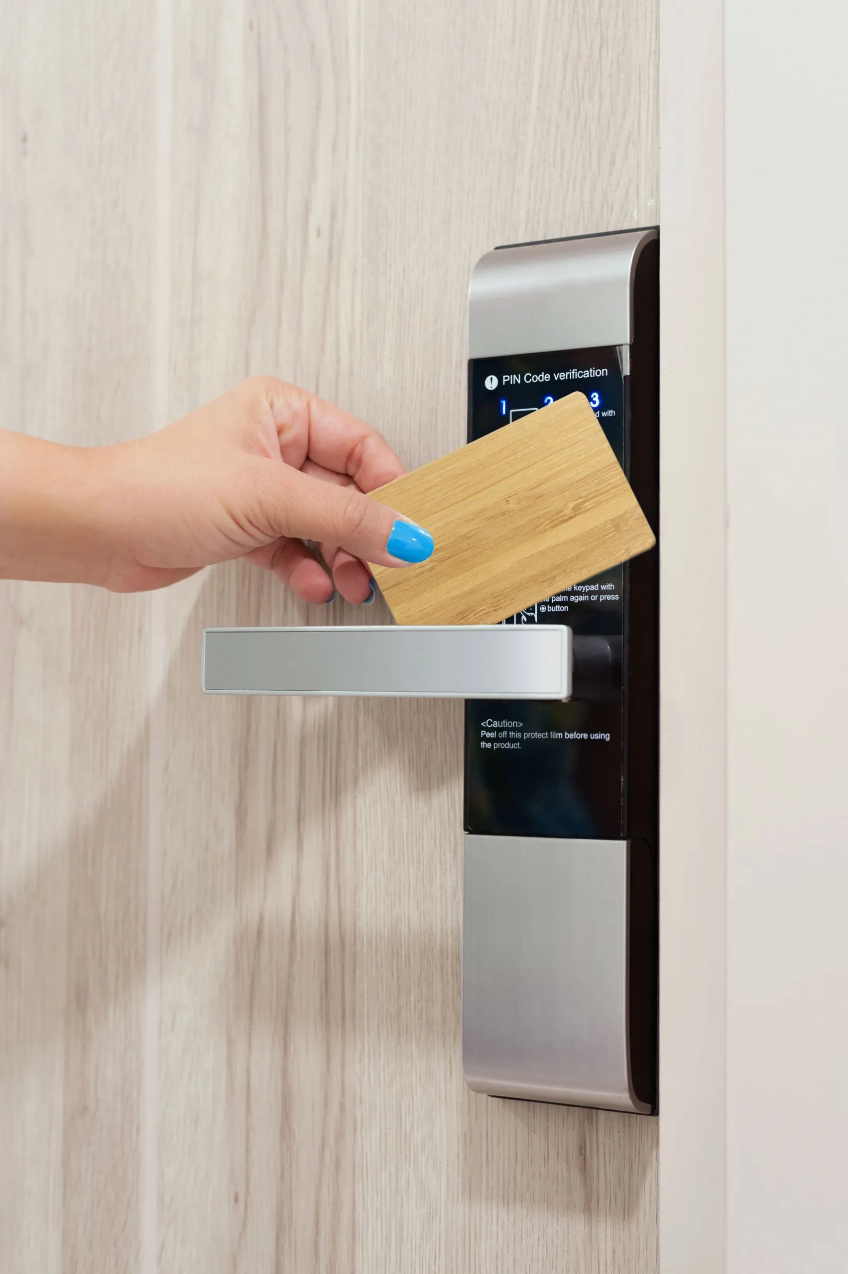 Mano insertando tarjeta llave RFID de hotel en lector de cerradura