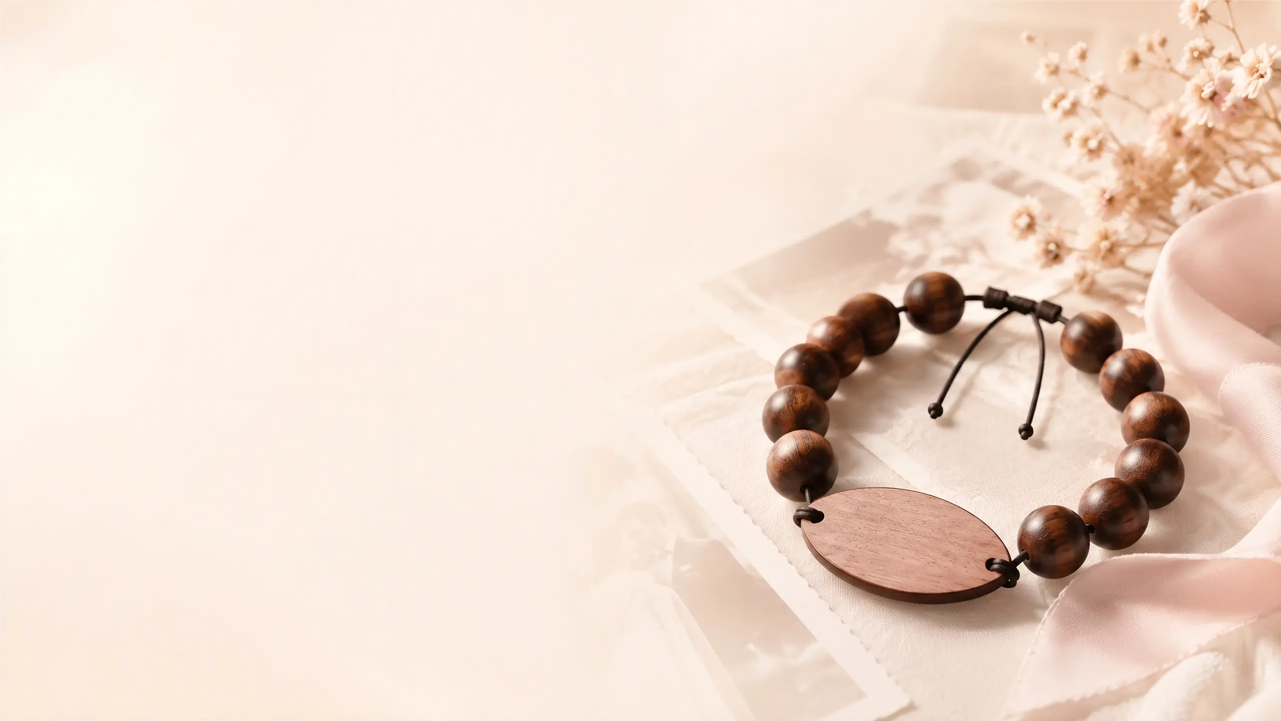 Engraved wooden bead NFC wristband by Wearable Wedding, manufactured by PrintPlast, resting on linen with dried flowers