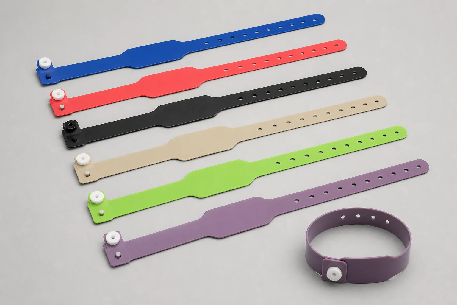 Production visualization of blank coral, teal, navy and white single-use PVC RFID wristbands for gym guest access