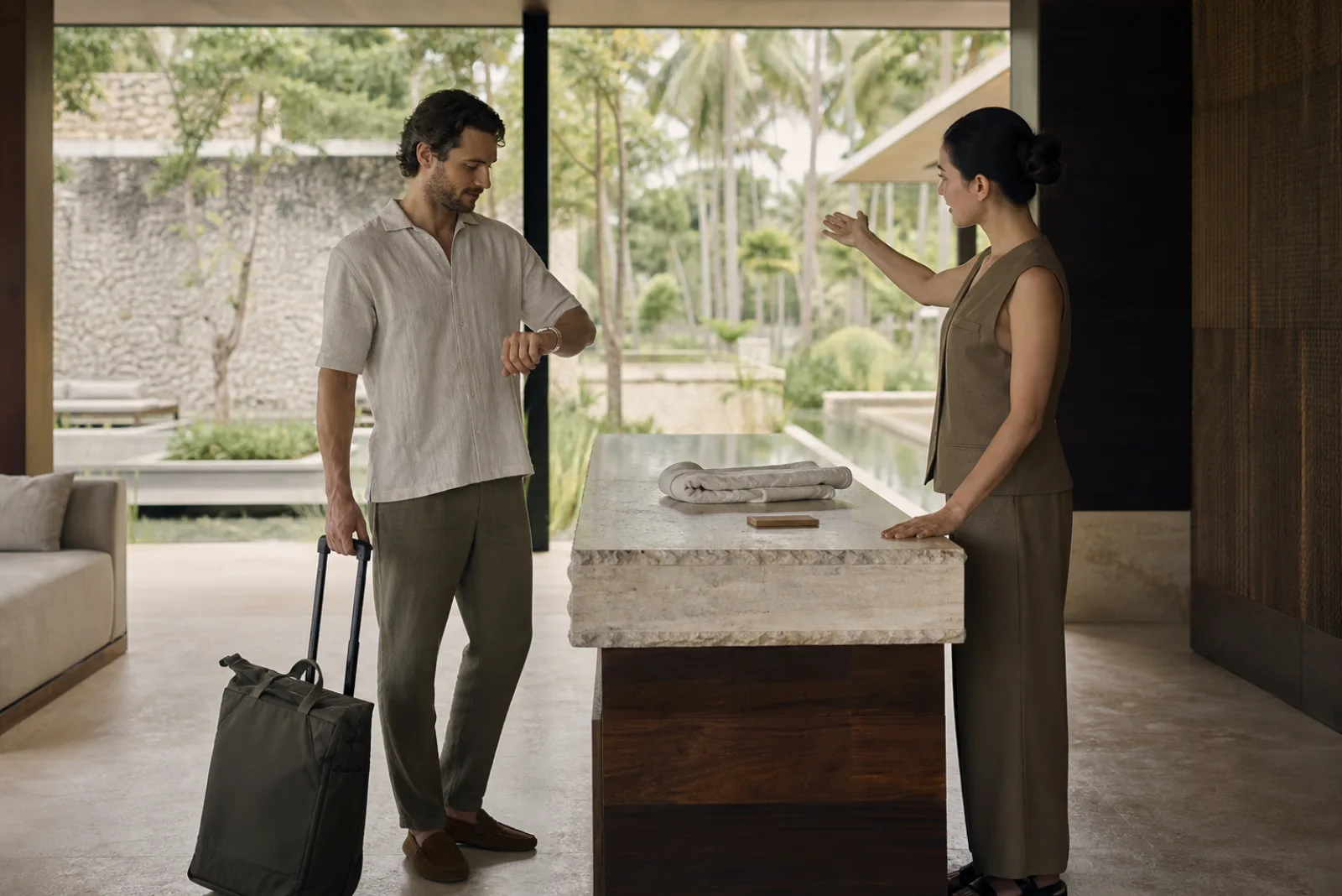 Guest and resort host completing a calm wellness retreat arrival with a fitted cream woven RFID wristband