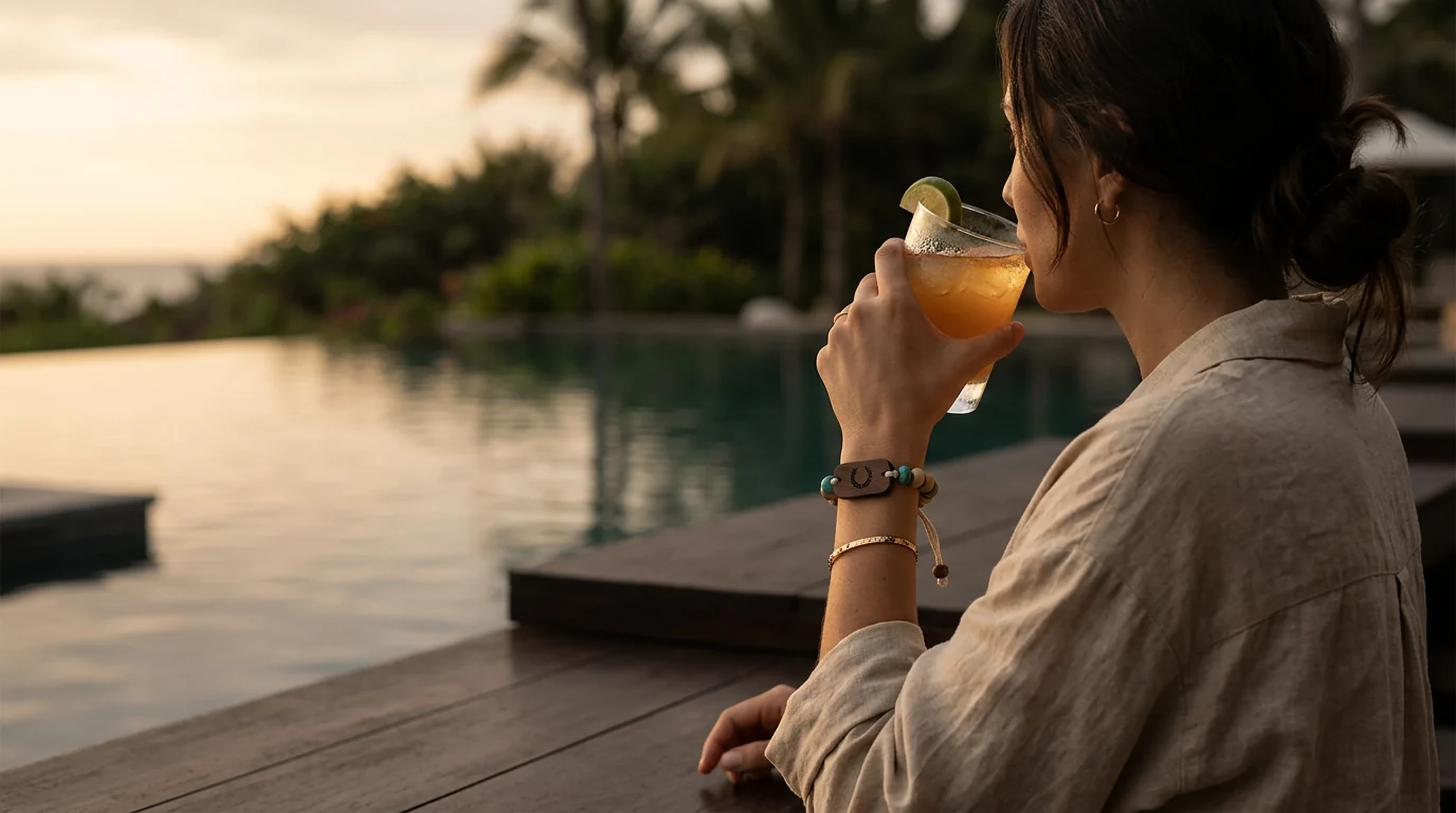 A resort guest wearing her engraved PrintPlast band, laughing as she shares a photo from the day on her phone.